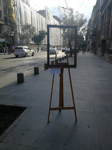 Ramă ornamentală pe un trotuar, încadrând perspectiva unei străzi din București